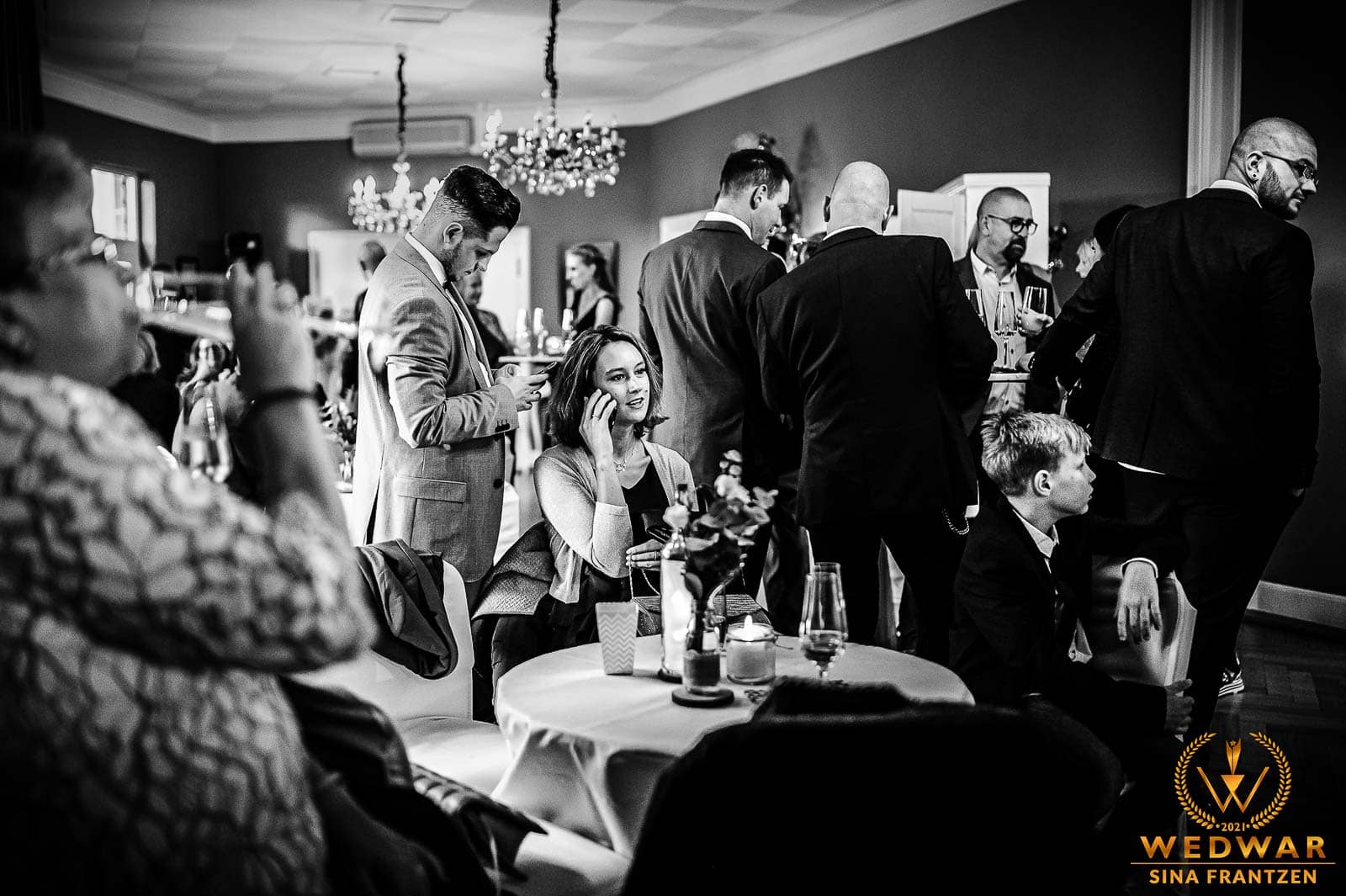 Hochzeitsgäste sind beschäftigt auf einer Hochzeit in der Schützengesellschaft am Brill in Wuppertal. - Gewinnerbild Wedwar Awards - Hochzeitsfotografin Sina Frantzen bildsprache Remscheid