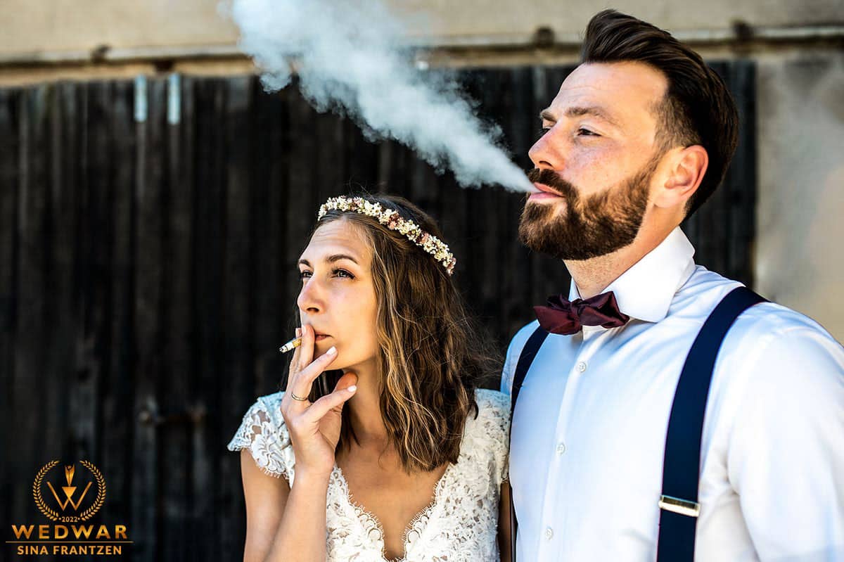 Hochzeitspaar entspannt bei einer Zigarette nach dem Paarshooting auf ihrer Hochzeit in Leverkusen. Gewinnerbild Wedwar Awards. Hochzeitsfotograf Remscheid Sina Frantzen