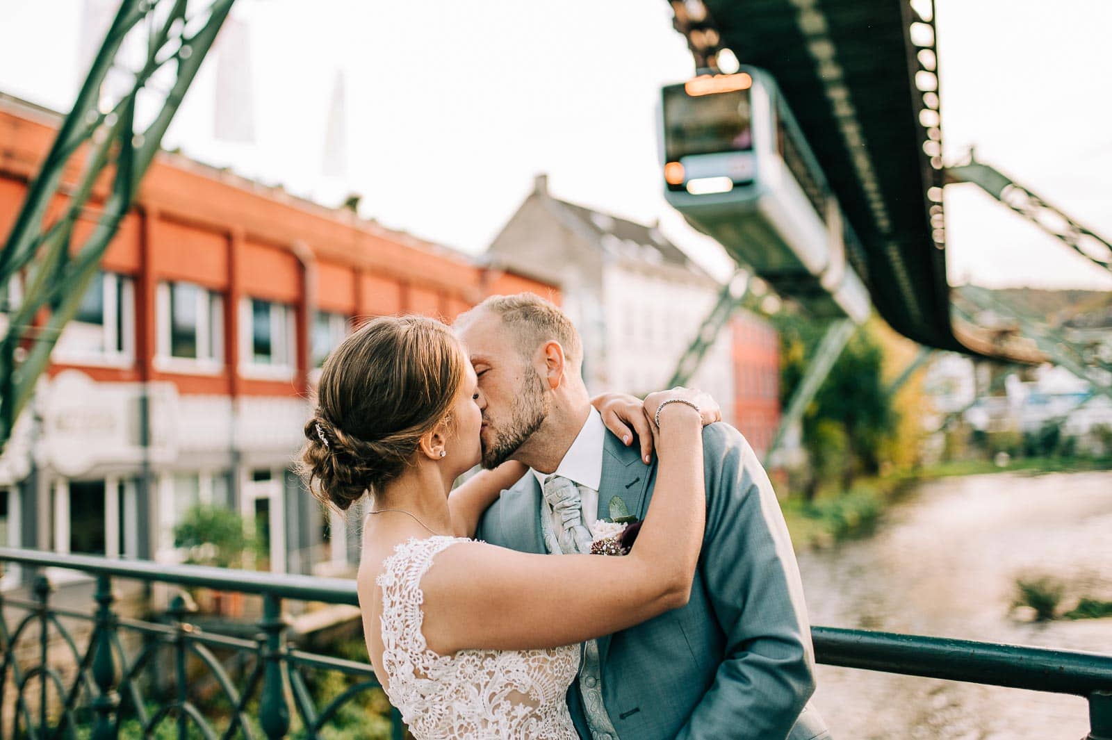Ein Kuss des Hochzeitspaares unter der Schwebebahn in Wuppertal bei der Hochzeit in der Schützengesellschaft Brill in Wuppertal| Hochzeitsfotografin Remscheid Sina Frantzen bildsprache