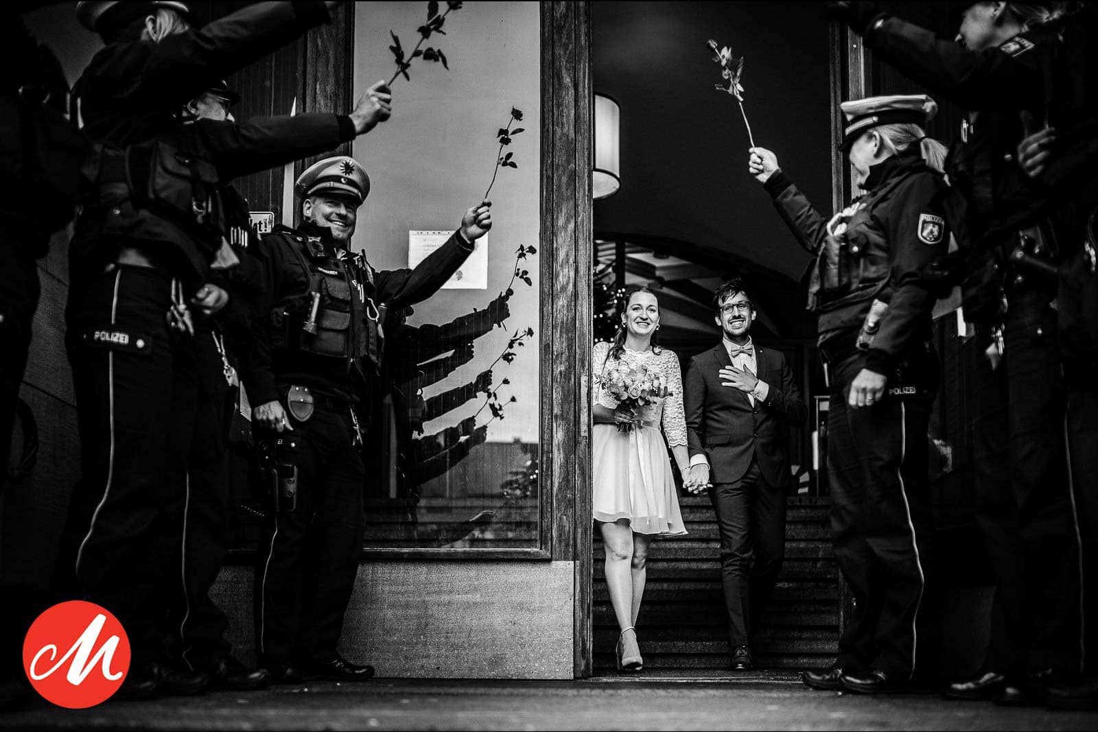 Hochzeitspaar wird von den Arbeitskolleg*innen der Polizei vorm Standesamt mit Rosen empfangen. - Gewinnerbild Masters Awards - Hochzeitsfotografin Sina Frantzen bildsprache Remscheid
