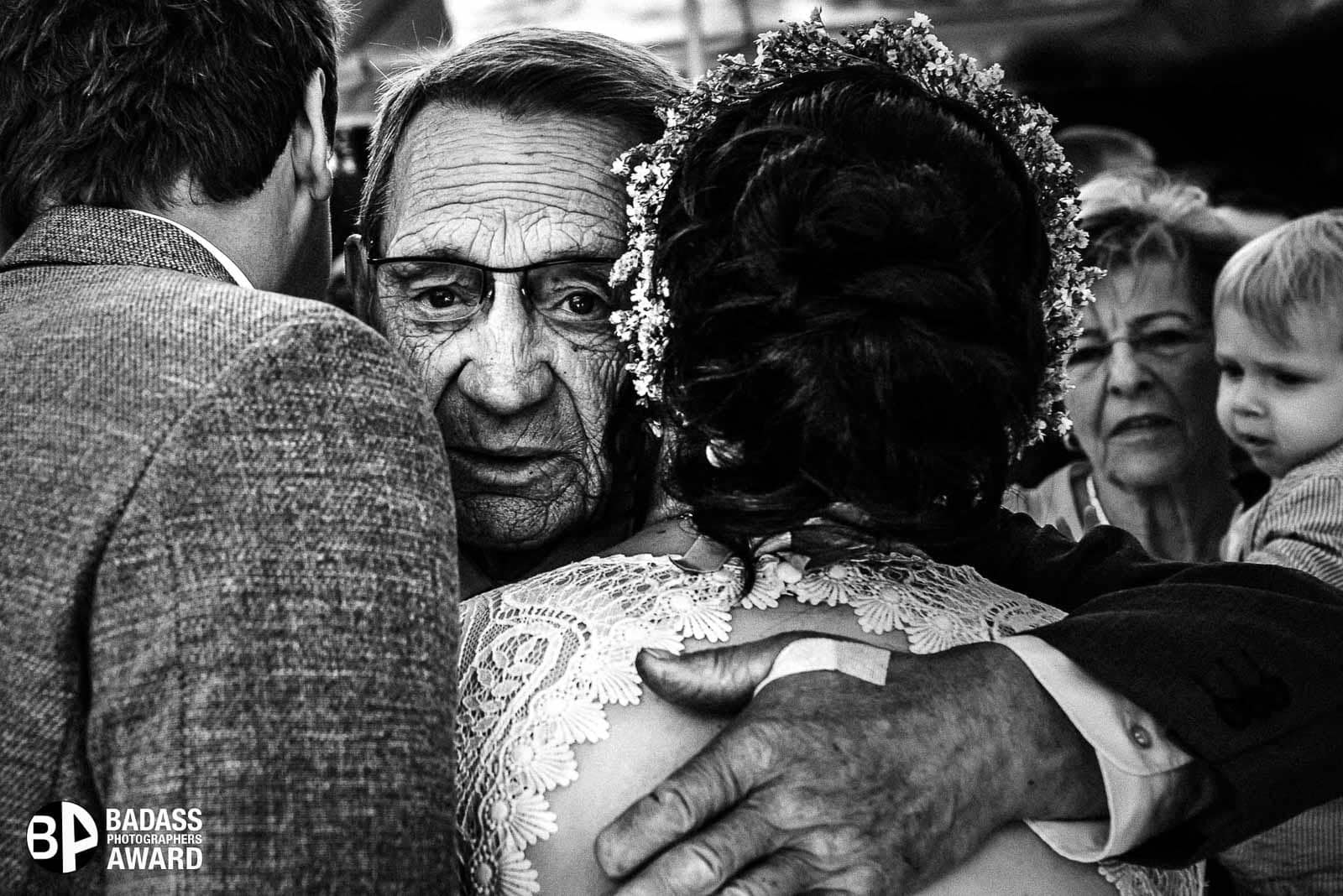 Großvater umarmt das Hochzeitspaar nach der Trauung. Gewinnerbild Badass Photographer Awards Collection 6 Hochzeitsfotografin Remscheid Sina Frantzen bildsprache