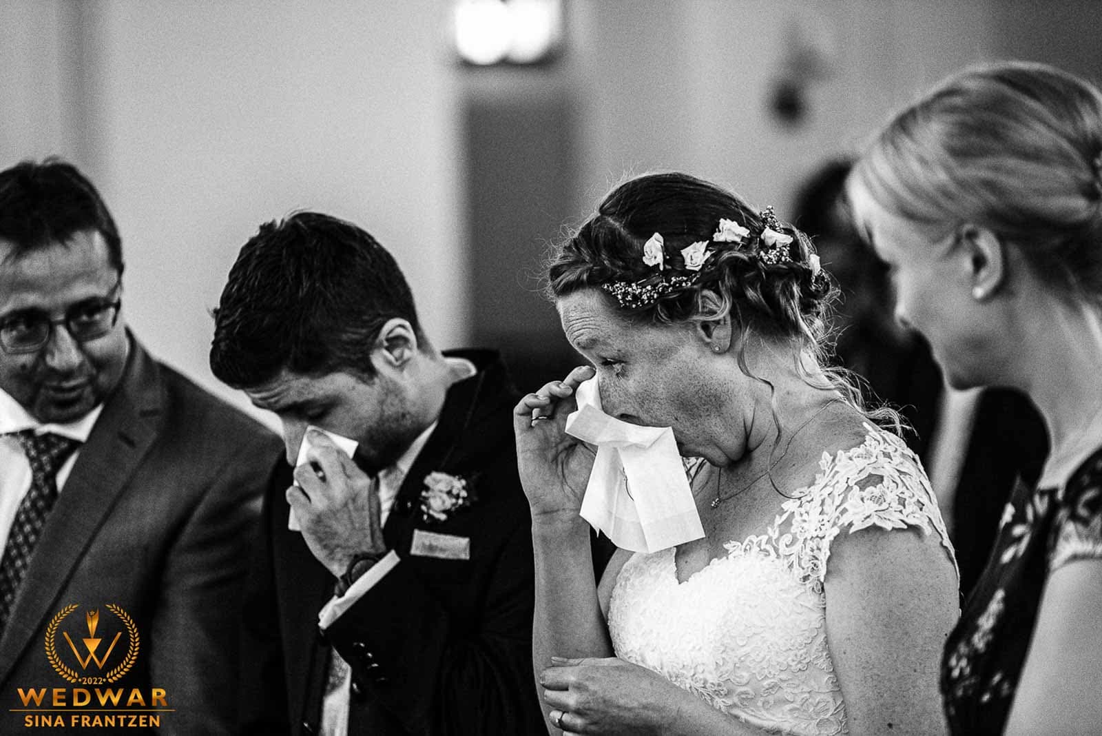Hochzeitspaar wischet sich die Tränen in der Kirche aus den Augen. . Gewinnerbild Wedwar Awards. Hochzeitsfotografin Remscheid bildsprache Sina Frantzen